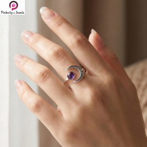 Sterling silver crescent moon ring with natural amethyst gemstone worn on woman’s hand in soft natural light